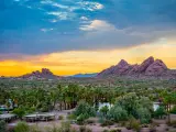 Papago Park, Phoenix, Arizona, USA after sunset with hills in the distance and desert landscape in the foreground.