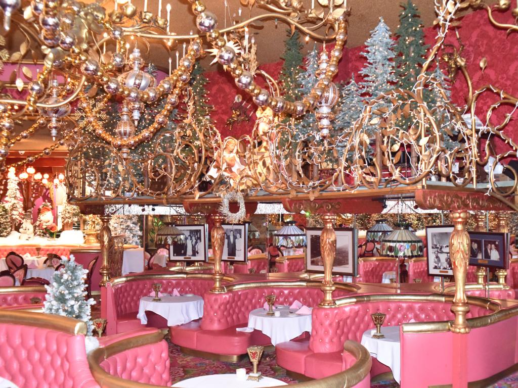Opulent pink dining room at the Madonna Inn, with extravagant chandeliers and pink, booth style seats
