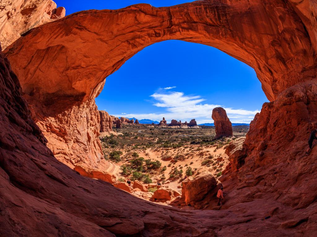 Arches National Park, USA with the stunning natural beauty of the Double Arch rock formation and looking through to the park beyond on a sunny clear day.