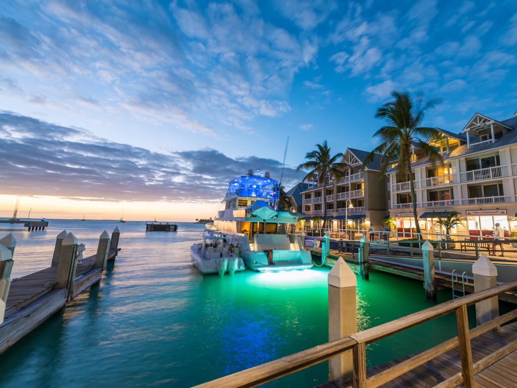 Key West, Florida, USA taken at the pier on the port of Key West at sunset with resorts and a boat.