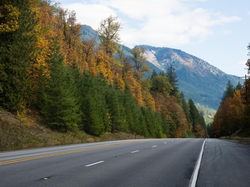 U.S. Route 2 Highway in fall, highway leading to the Cascade Mountains surrounded by trees