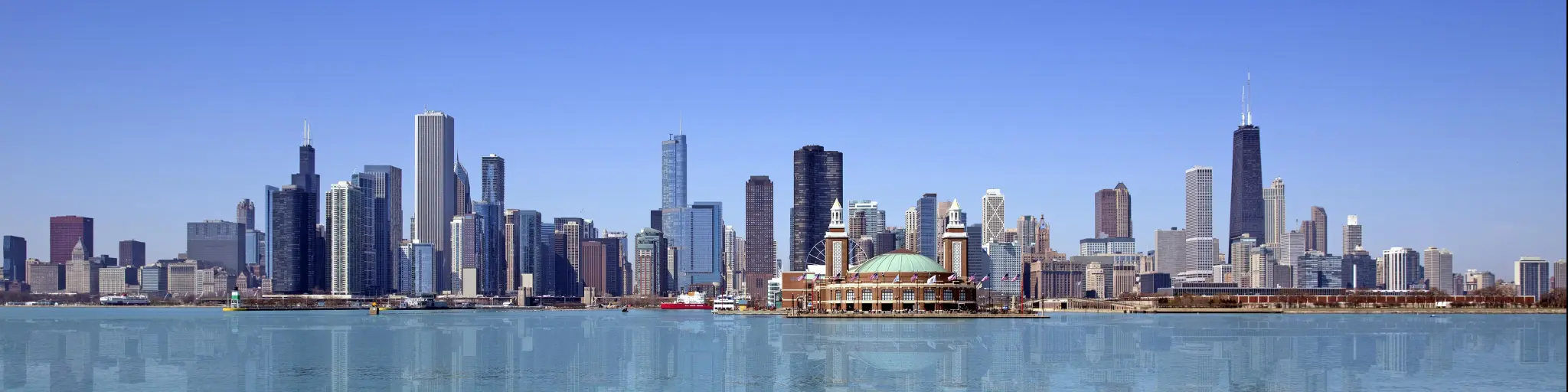 Chicago, USA with the city skyline against a blue sky with water in the forehand. 