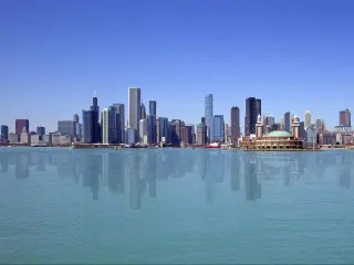 Chicago, USA with the city skyline against a blue sky with water in the forehand. 