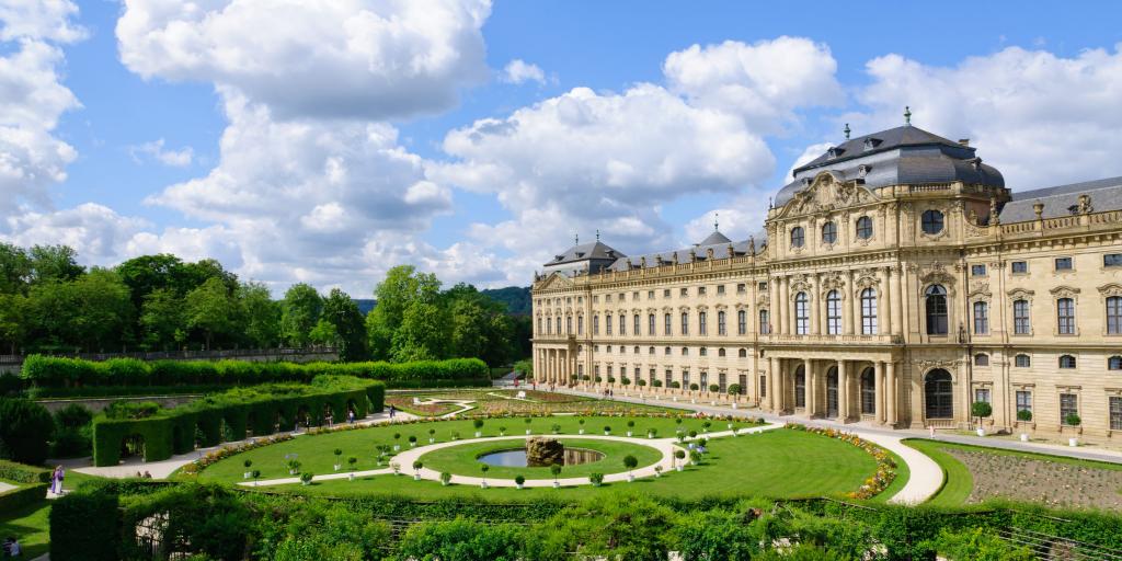 The cream baroque style outside of the Würzburger Residenz with circular gardens in front