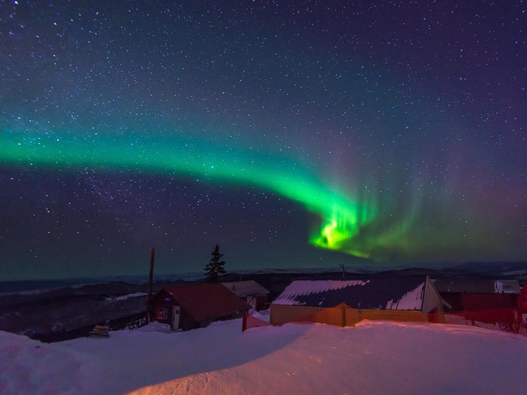 Fairbanks, Alaska with the Northern lights,Aurora borealis, dancing over Fairbanks at night which is covered in snow.