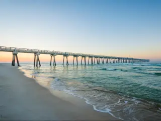M.B. Miller County Pier and Gulf of Mexico at sunrise, in Panama City Beach, Florida, with white sands below