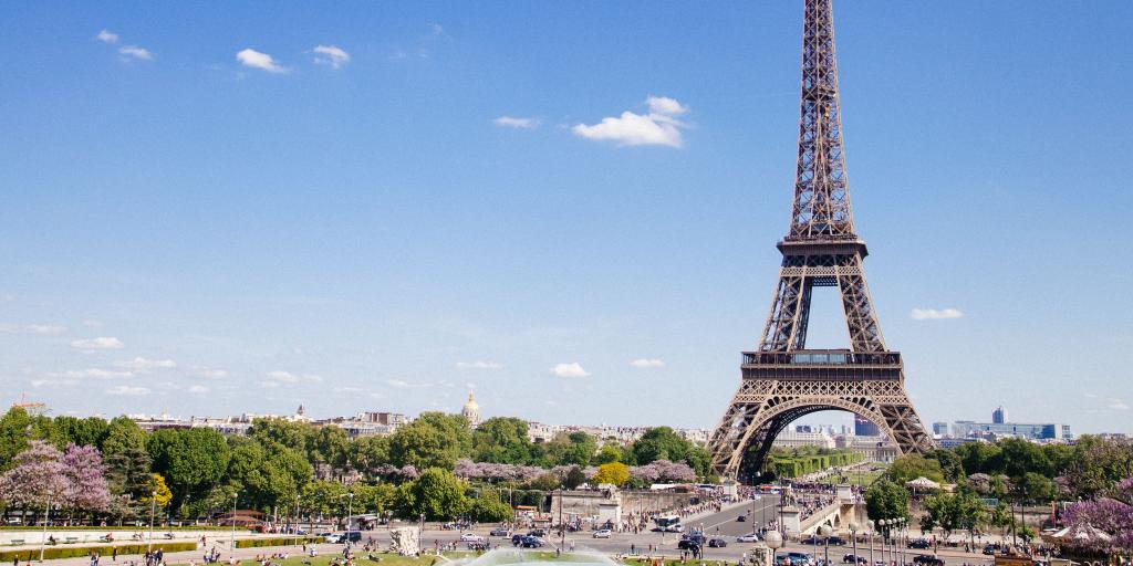 The Eiffel Tower of Paris stands tall on a sunny day in the French capital