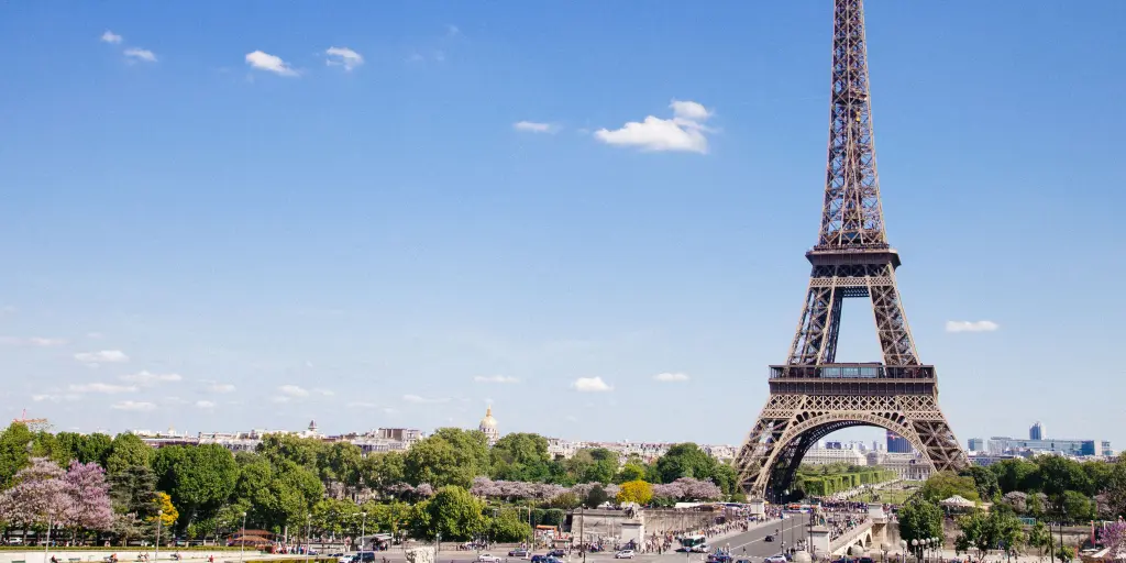 The Eiffel Tower of Paris stands tall on a sunny day in the French capital