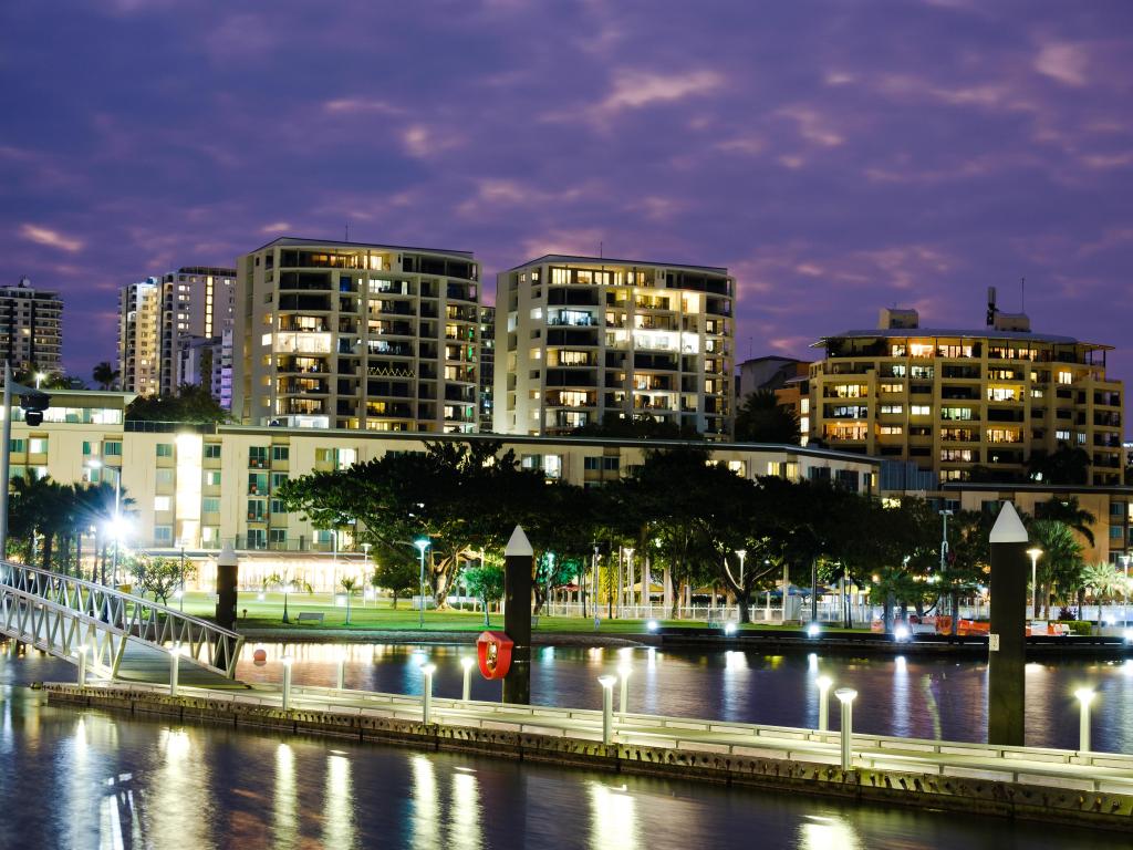 Darwin, Northern Territory, Australia taken at the waterfront bridge at sunset, night. Apartment buildings with sea views, balconies with light in the background.