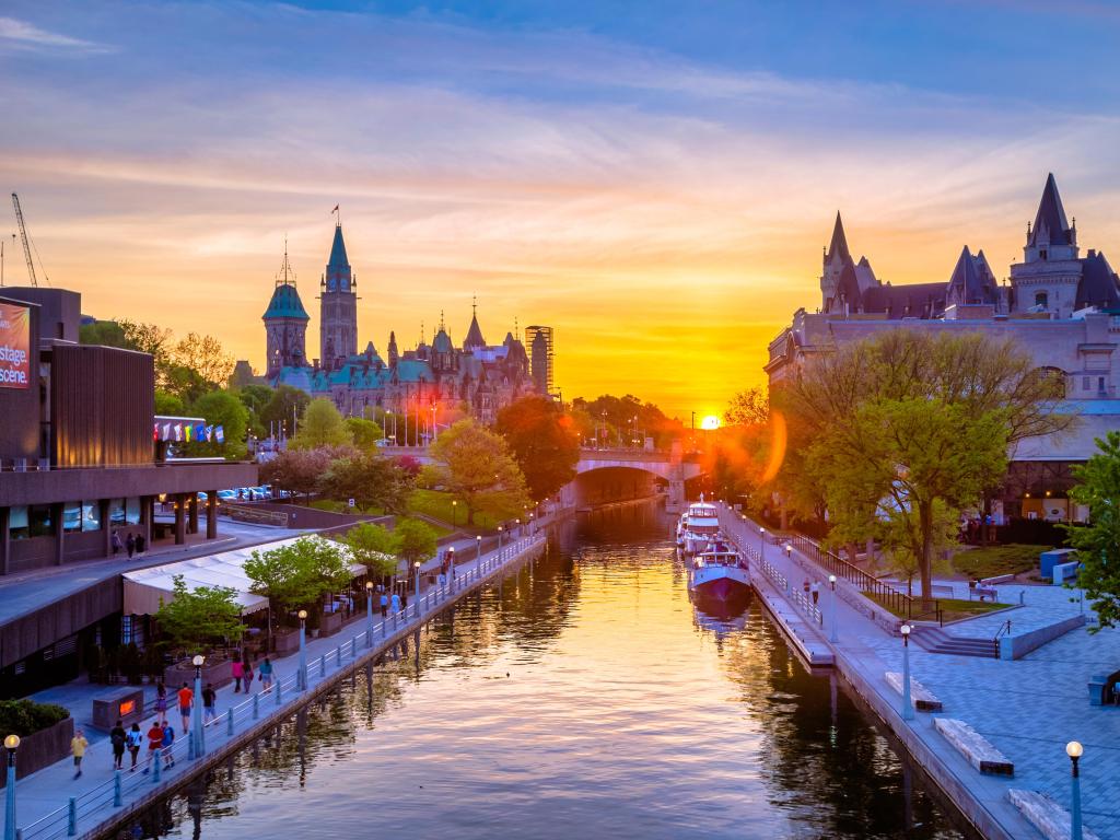 Ottawa City, Canada with buildings either side of the canal, the Mackenzie King bridge in the background during sunset.