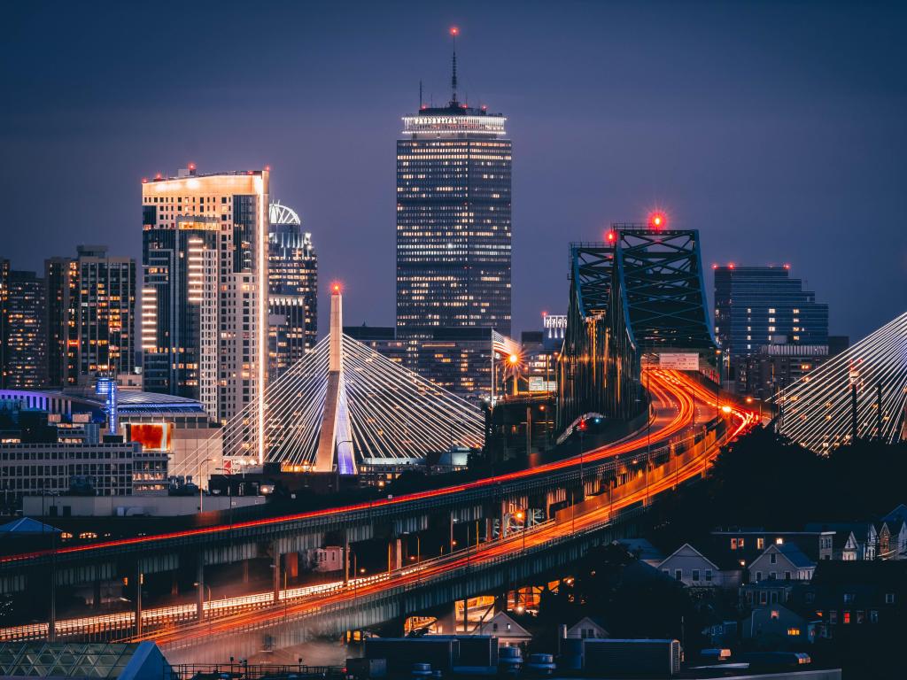 Boston, USA with the city skyscrapers in the background and a bridge leading to the city at night.