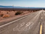 Panoramic view of Route 66 road to Joshua Tree National Park on a sunny day, with mountains in the background