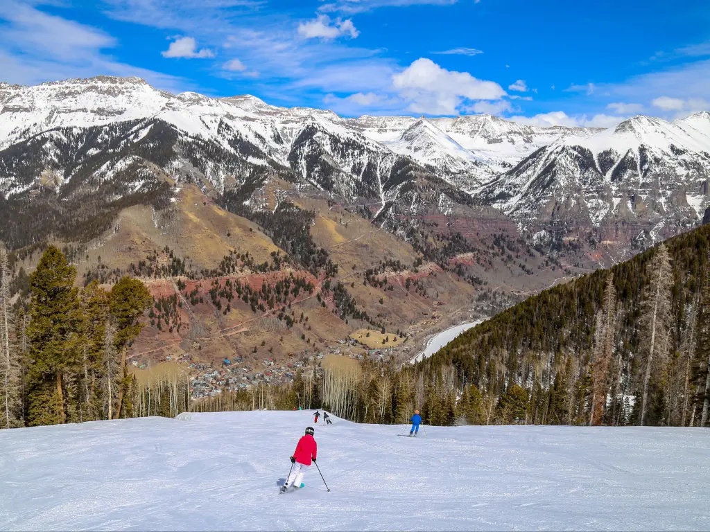 White slopes and downhill skiing with woodlands and mountains in the distance, in Telluride, Colorado, USA