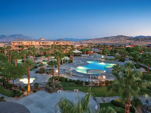 Aerial shot of the resort complex with a lit up pool and palms in the center