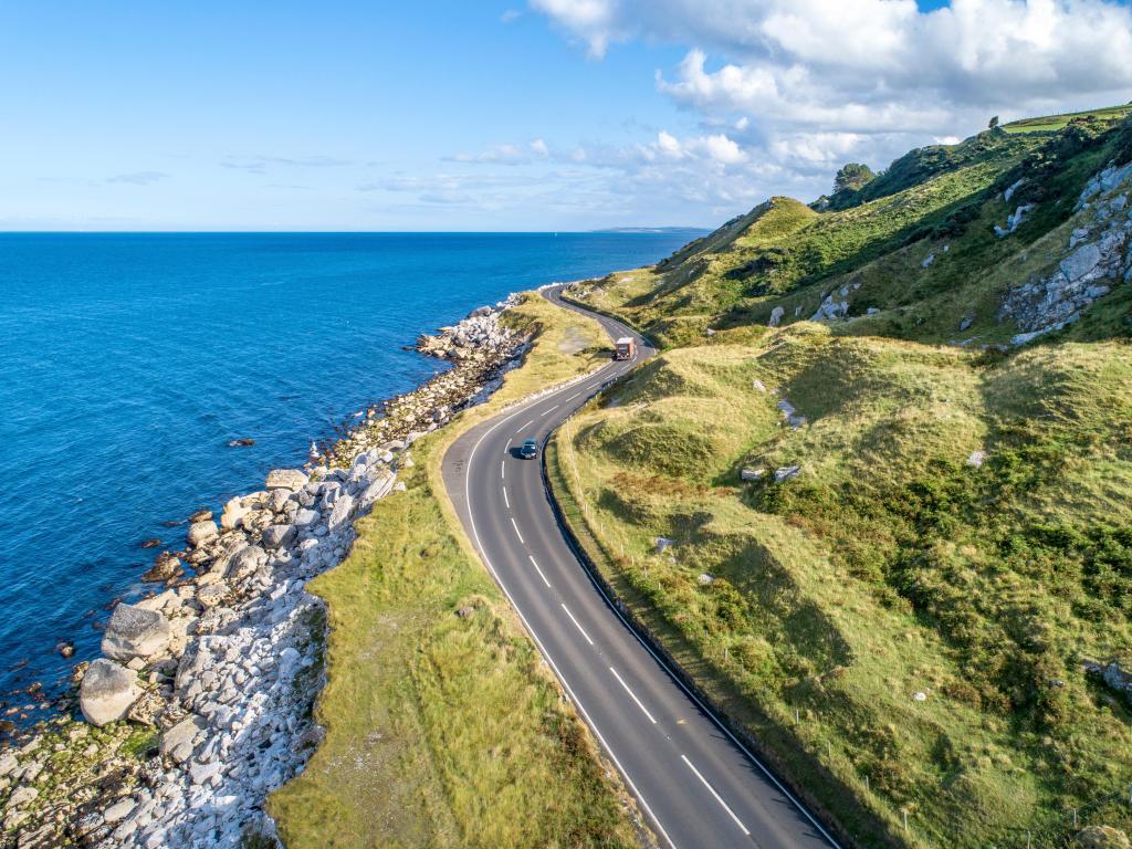 Causeway Coastal Route with cars, a.k.a. Antrim Coastal Road on eastern coast of Northern Ireland, UK.