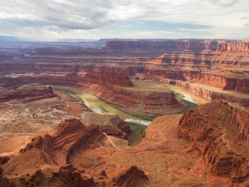 Dead Horse National Park, USA with an incredible view over the Colorado river and canyons in the distance on a cloudy but sunny day.