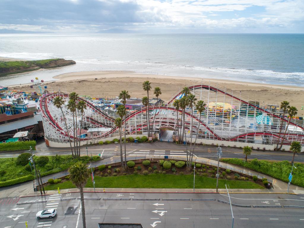 Ariel view over Santa Cruz Beach Boardwalk, with vintage rides and roller coaster along the beach front