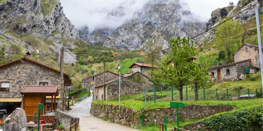 A road winds up through the mountain village of Cain on a cloudy day in Picos de Europa