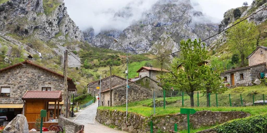 A road winds up through the mountain village of Cain on a cloudy day in Picos de Europa
