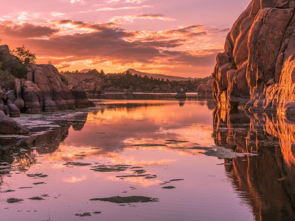 Prescott, Arizona, USA with a view of Watson Lake at sunset, rocks reflecting in the waters edge.