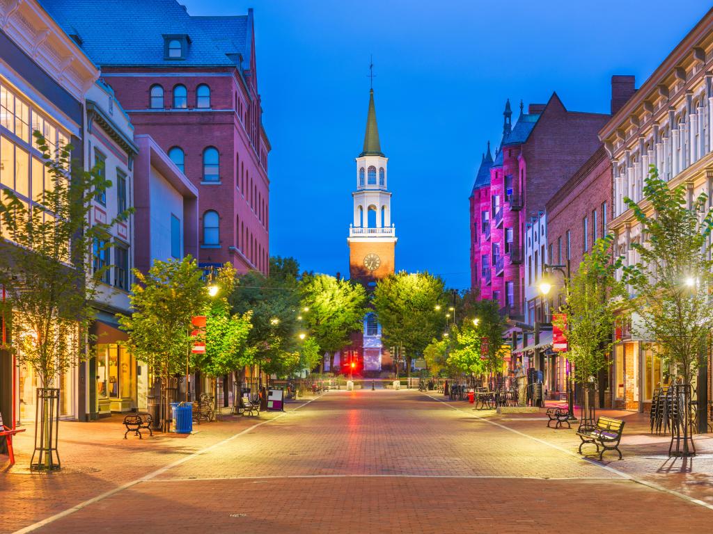 Burlington, Vermont, USA at Church Street Marketplace at evening with trees lining the street and the clock tower in the distance.
