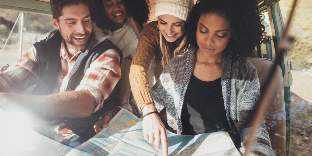 Friends looking at a map on their road trip 