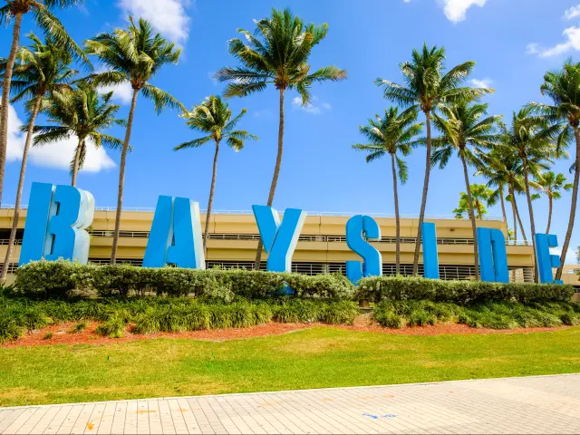 Blue-colored sign of the Bayside Marketplace in downtown Miami on a sunny day