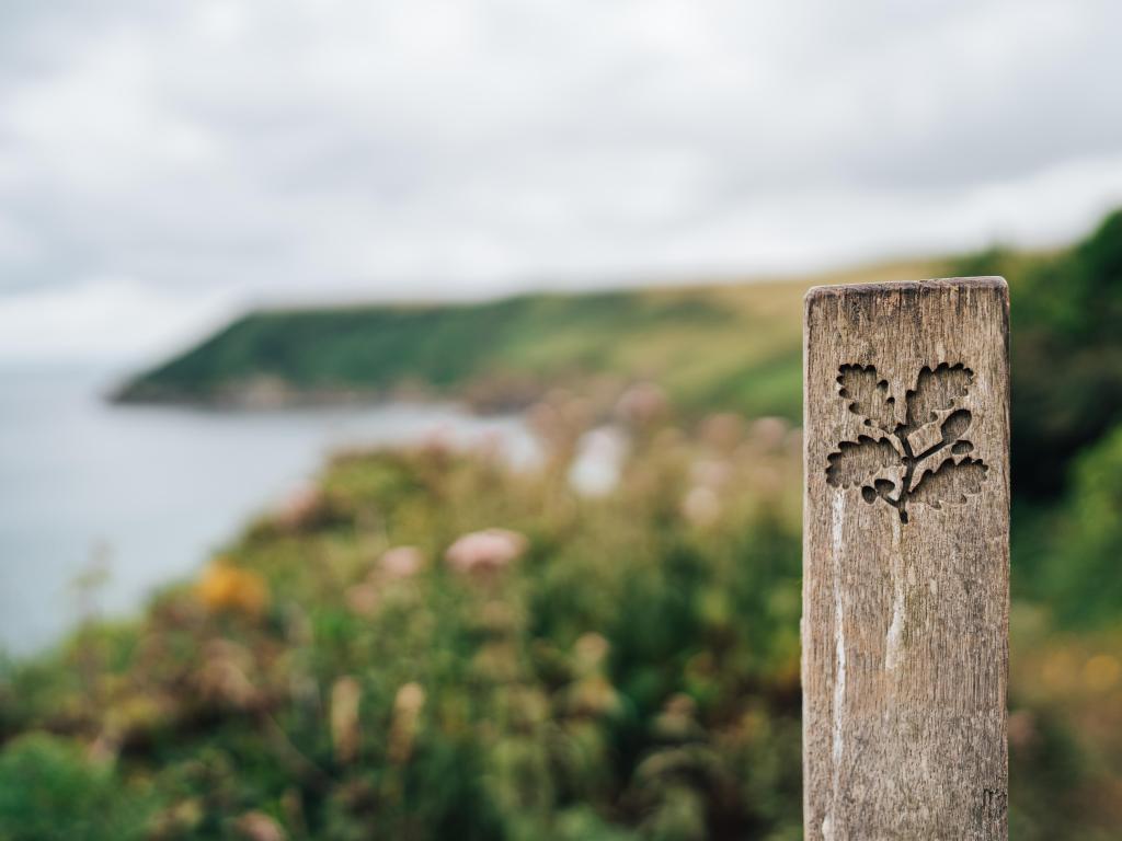 National Trust sign on Cornwall coast path with a view