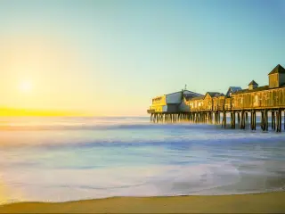 Early morning by the ocean with sunrise. Long exposure Wooden old pier leaving in the sea with wooden buildings. USA. Portland. Maine