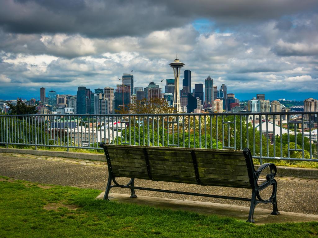 Seattle, Washington, USA with a bench and view of the downtown Seattle skyline in the foreground on a cloudy day.