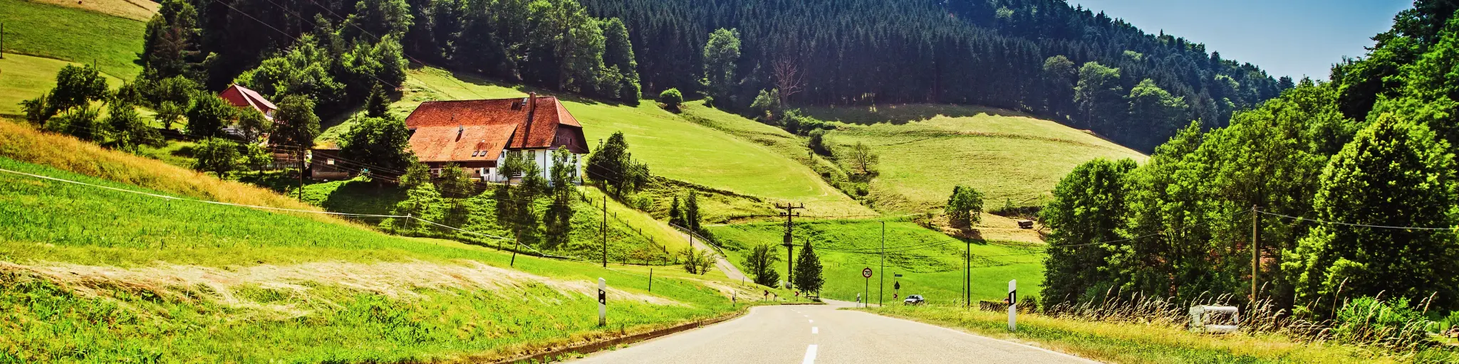 Cars on a German road with mountains and lush green hills in the background