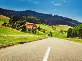 Cars on a German road with mountains and lush green hills in the background