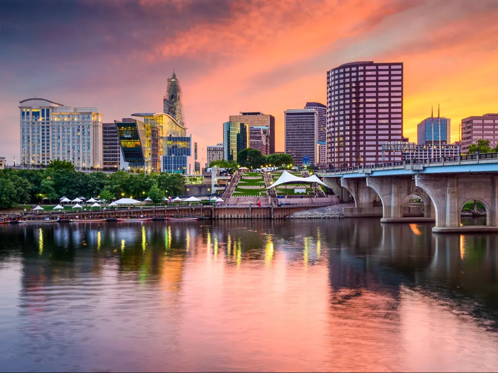 Hartford, Connecticut, USA with the river in the foreground and a road bridge crossing over to the downtown skyline in the background taken at sunset.