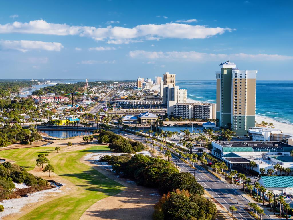 Panama City Beach, Florida, USA, view of Front Beach Road with greenery behind, skyscrapers facing the beach and sea and taken on a sunny day.