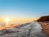 Thunder Cove, Prince Edward Island, Canada with the ocean coast at the sunrise and red cliffs in the distance.