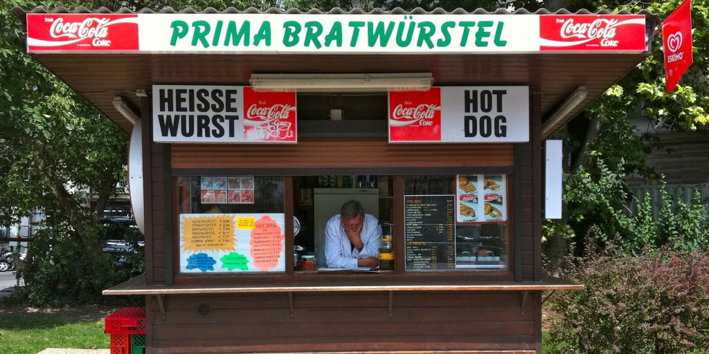 Man sits inside a hot dog stand in Vienna