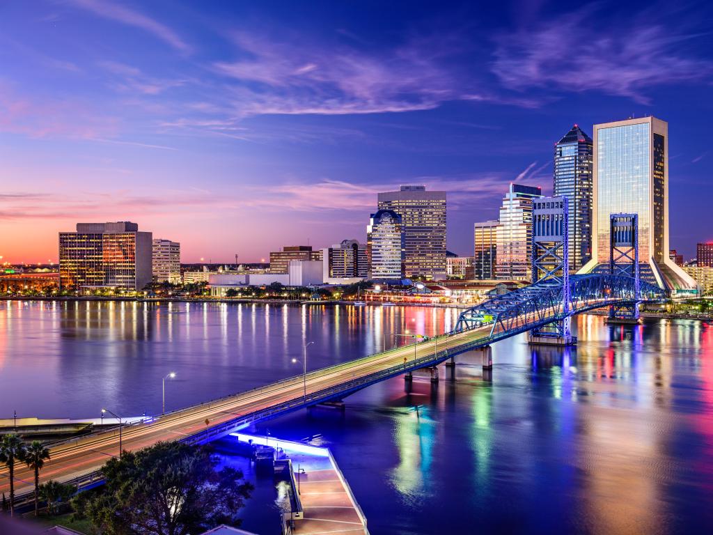 Jacksonville, Florida, USA downtown city skyline taken at night with the bridge in the foreground. 