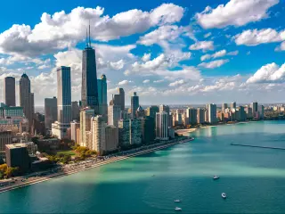 Chicago, Illinois, USA with the skyline aerial drone view from above, city of Chicago downtown skyscrapers and Lake Michigan in the foreground taken on a sunny but cloudy day.