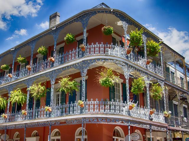 Ornate wrought iron balconies with hanging plants in New Orleans' French Quarter, Louisiana