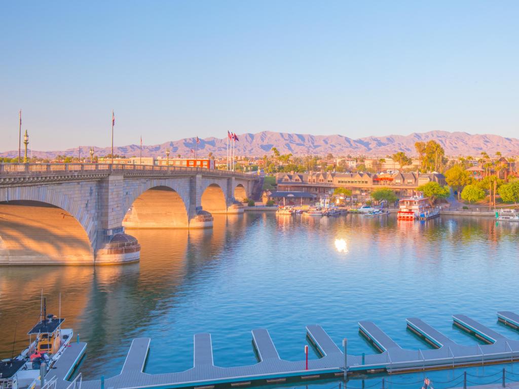 Lake Havasu City, Arizona, USA with a view of  London Bridge and surrounding English Village at sunset. Boat dock of the Heat Hotel to the front. Twilight colors reflect beautifully onto buildings on the other side.
