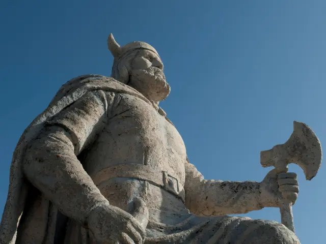 Stone Viking statue, photo taken from below on a sunny day