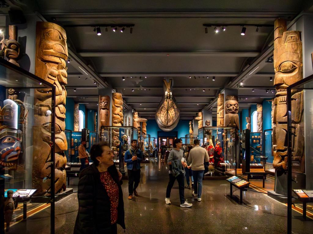 Visitors enjoying the interior of American Museum of Natural History’s Hall of Northwest Coast Indians, with 78 totem poles