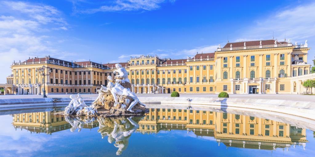 The yellow exterior of Schönbrunn Palace, Vienna, with a fountain in the foreground