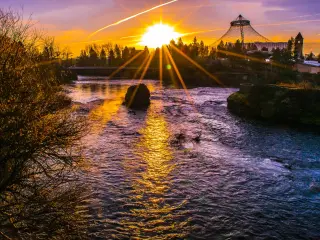 Orange sunrise over the river and trees in Spokane