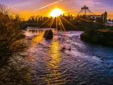Orange sunrise over the river and trees in Spokane