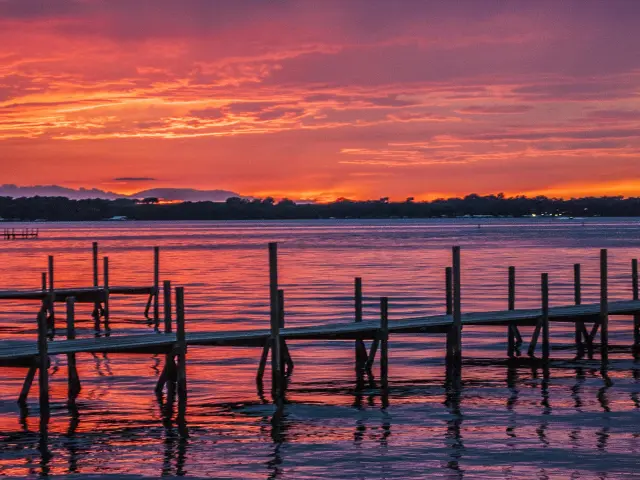 Fiery sunset at the lake, with a wooden dock in view