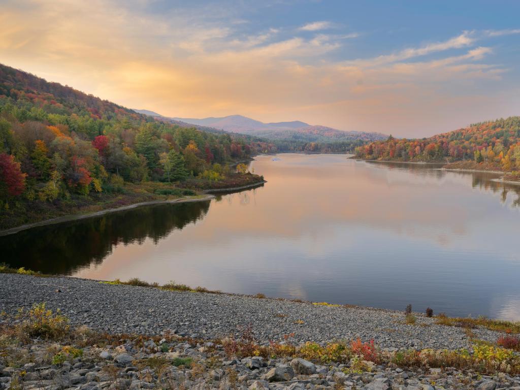 Montpelier, Green Mountains, Vermont taken at Wrightsville Reservoir at sunset with the lake in the foreground and fall trees in the distance. 