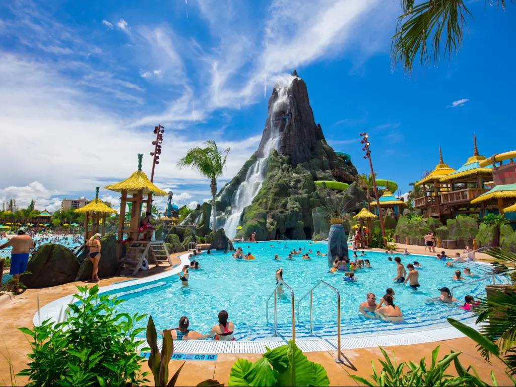 Universal Orlando Resort, Orlando at a water park with a volcano and pool in the foreground on a sunny day.