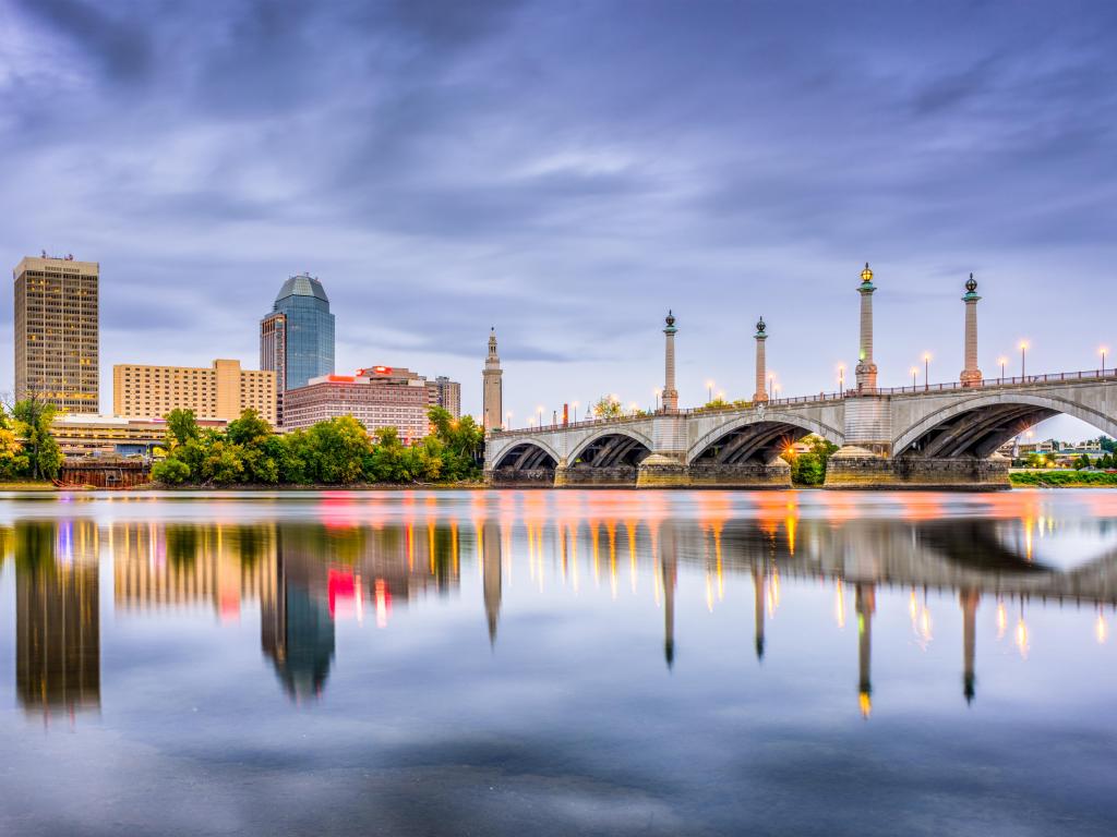 Springfield, Massachusetts, USA downtown skyline taken at early evening with a view of the river, bridge and city in the distance. 