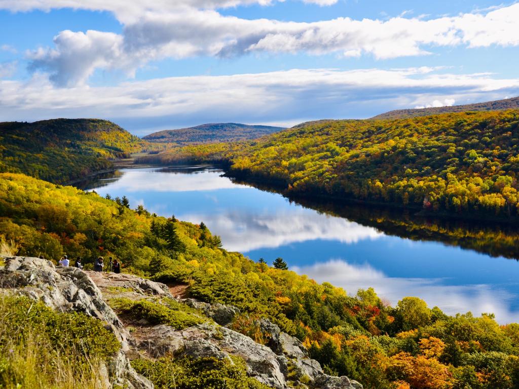 Porcupine Mountains Wilderness State Park, Michigan, USA with a view of Lake of the Clouds in surrounded by amazing natural beauty in fall season and gorgeous blue clouds reflection in water.